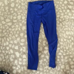 Bright blue 3/4 length leggings with mesh panel on outer leg.